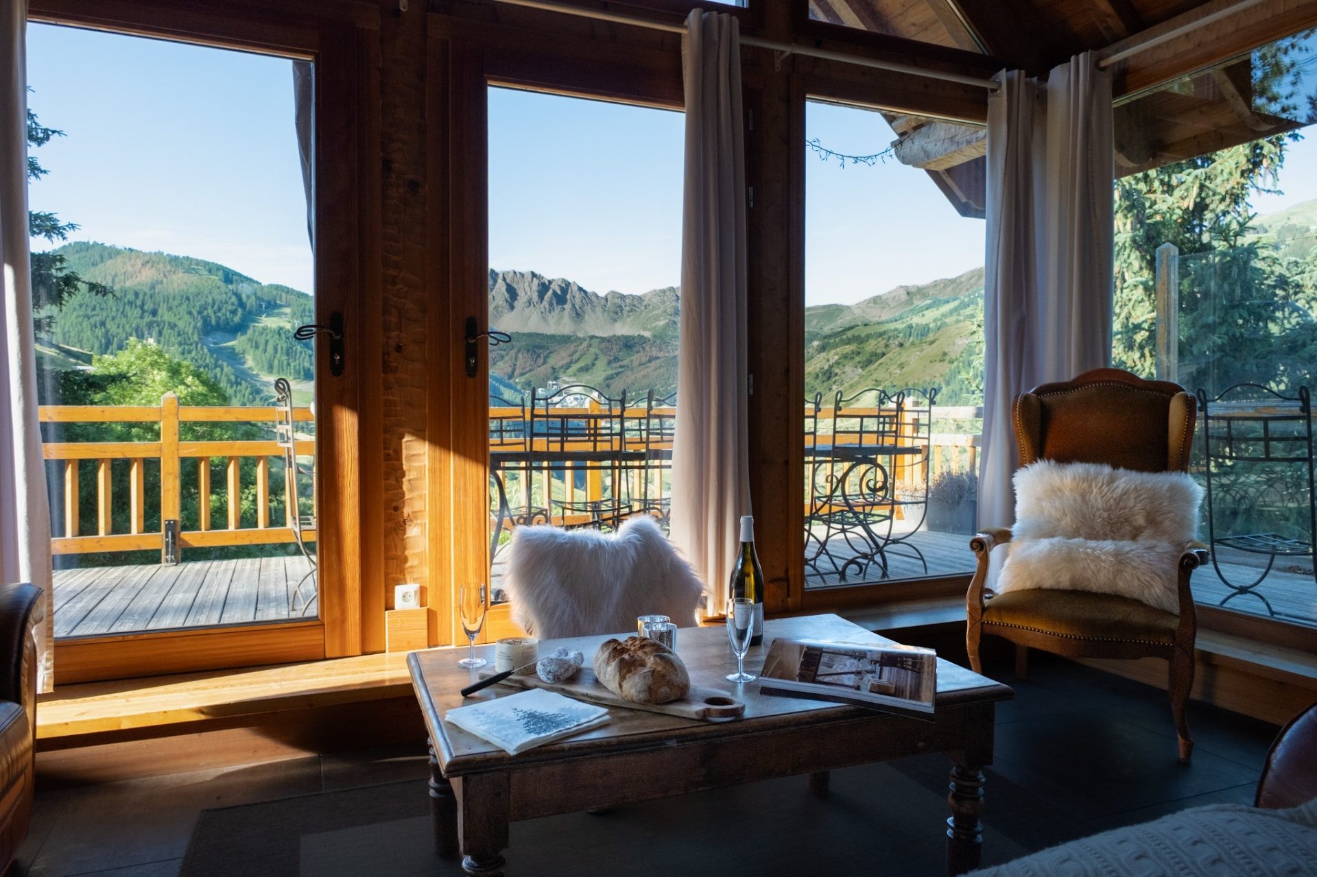 Un appartement alpin au lever du jour, fenêtre ouverte sur les sommets